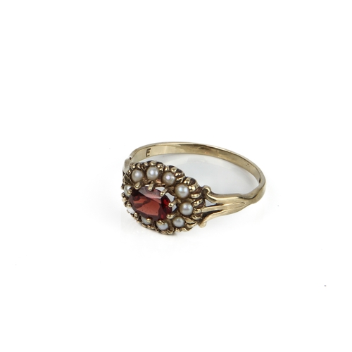 212 - A 9ct yellow gold, garnet and seed pearl cluster ring - hallmarked Birmingham 1989, the oval cut gar... 