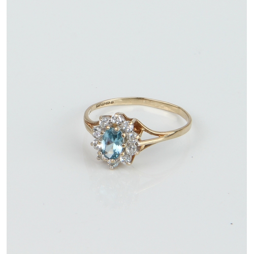 236 - A 9ct yellow gold, topaz and white stone cluster ring - the oval cut 5.5 x 3.75mm topaz within a bor... 