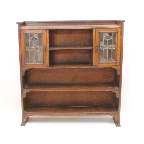 431 - An early 20th century oak and stained-glass bookcase in the Arts & Crafts style - the shallow galler... 