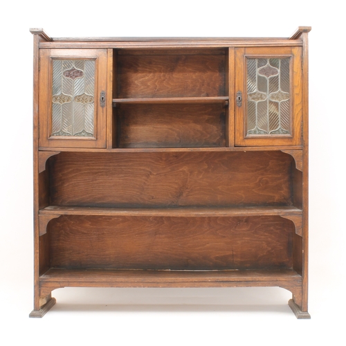 431 - An early 20th century oak and stained-glass bookcase in the Arts & Crafts style - the shallow galler... 