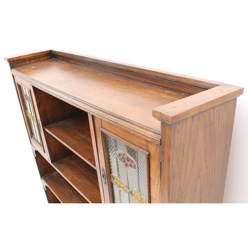 431 - An early 20th century oak and stained-glass bookcase in the Arts & Crafts style - the shallow galler... 