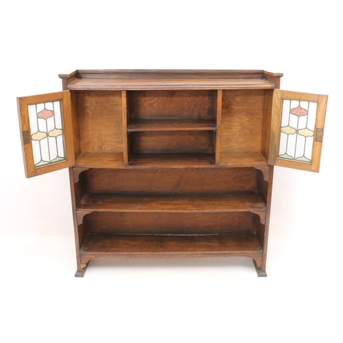 431 - An early 20th century oak and stained-glass bookcase in the Arts & Crafts style - the shallow galler... 