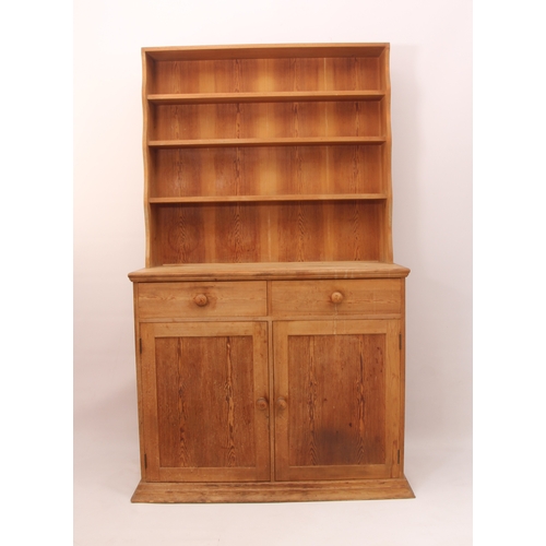 457 - A waxed-pine Victorian-style dresser of compact proportions - the top section with wavy sides and th... 