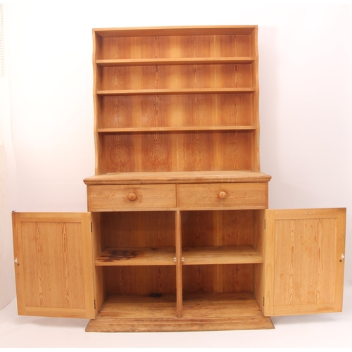 457 - A waxed-pine Victorian-style dresser of compact proportions - the top section with wavy sides and th... 