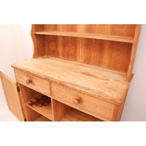 457 - A waxed-pine Victorian-style dresser of compact proportions - the top section with wavy sides and th... 