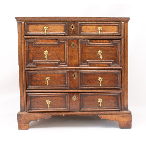 465 - A late-17th century panelled oak chest of drawers - the three-plank top over four panel sides and fo... 