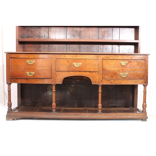 480 - A mid-18th century oak potboard dresser - the ogee cornice over a closed plate-rack with three shelv... 