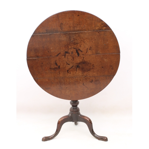 483 - A George III oak tilt-top tripod table - the circular top on a turned gun-barrel column to three swe... 