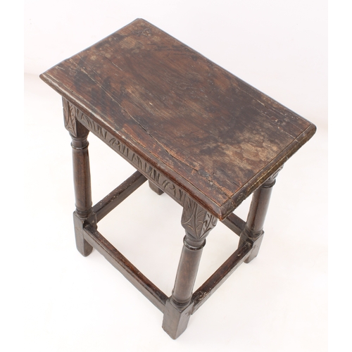 484 - An early 18th century oak and beech joint stool - the moulded top over a foliate arcaded frieze, rai... 