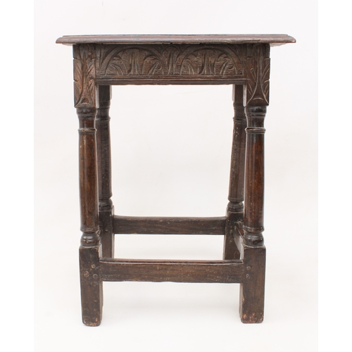 484 - An early 18th century oak and beech joint stool - the moulded top over a foliate arcaded frieze, rai... 