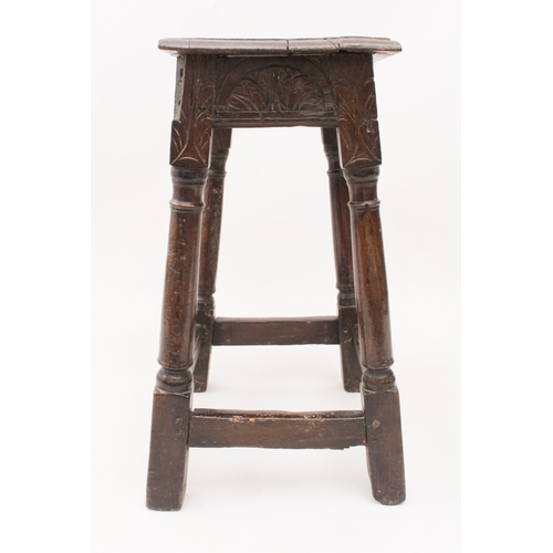 484 - An early 18th century oak and beech joint stool - the moulded top over a foliate arcaded frieze, rai... 