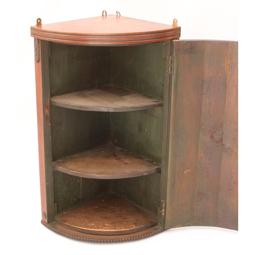 491 - A small bowfront mahogany hanging corner cupboard - early 20th century, with green painted two-shelf... 