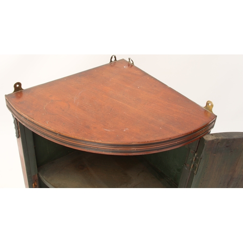 491 - A small bowfront mahogany hanging corner cupboard - early 20th century, with green painted two-shelf... 