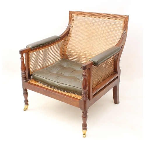 492 - A Regency mahogany and leather bergère - the reeded rectangular scrolled back over swept reeded arms... 