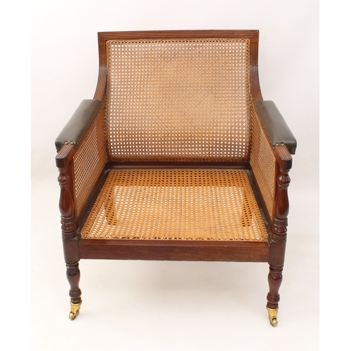 492 - A Regency mahogany and leather bergère - the reeded rectangular scrolled back over swept reeded arms... 