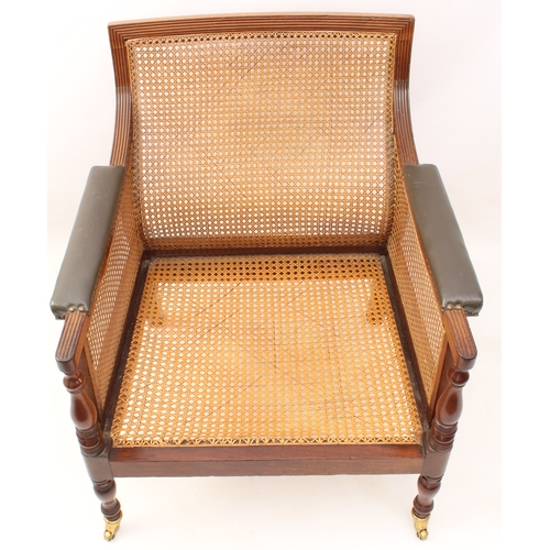 492 - A Regency mahogany and leather bergère - the reeded rectangular scrolled back over swept reeded arms... 