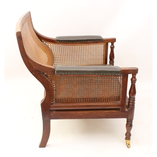 492 - A Regency mahogany and leather bergère - the reeded rectangular scrolled back over swept reeded arms... 