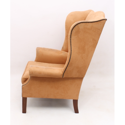 495 - A George III style wing armchair - upholstered in studded pale-tan suede, raised on square tapered l... 