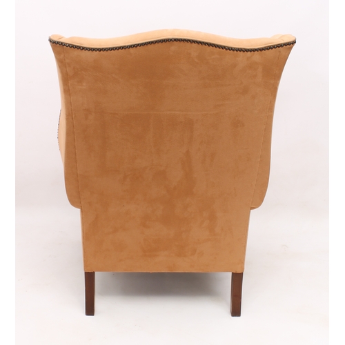 495 - A George III style wing armchair - upholstered in studded pale-tan suede, raised on square tapered l... 