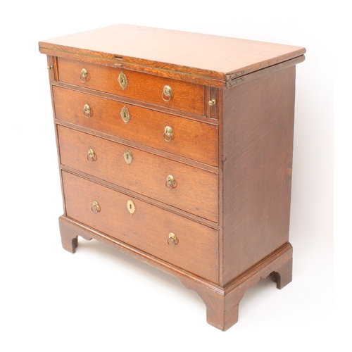 498 - A mid-18th century oak bachelor's chest - the rectangular fold-over top opening on lopers, lined wit... 