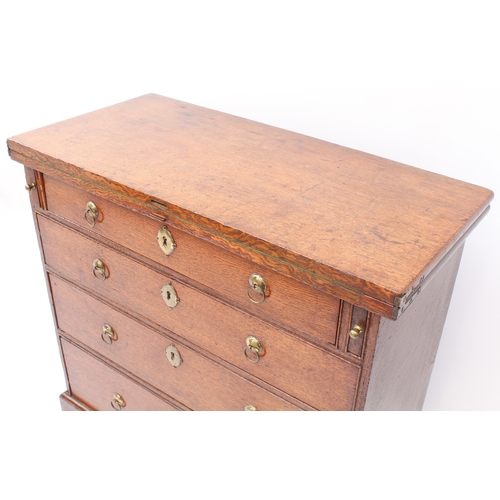 498 - A mid-18th century oak bachelor's chest - the rectangular fold-over top opening on lopers, lined wit... 