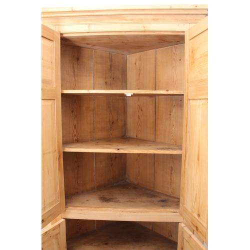 505 - A stripped pine floorstanding corner cupboard in the early 19th century style - the moulded cornice ... 