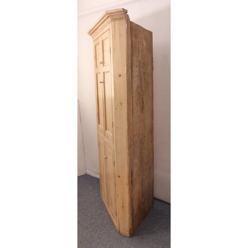 505 - A stripped pine floorstanding corner cupboard in the early 19th century style - the moulded cornice ... 