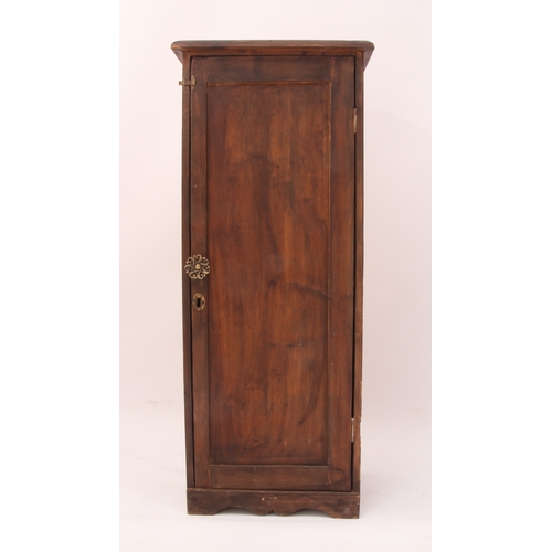 514 - A narrow stained pine cupboard - early 20th century, the panelled door enclosing a two-shelf interio... 