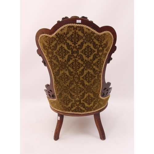 517 - A Victorian carved walnut showframe lady's chair - the frame with a buttoned spoon back, carved and ... 