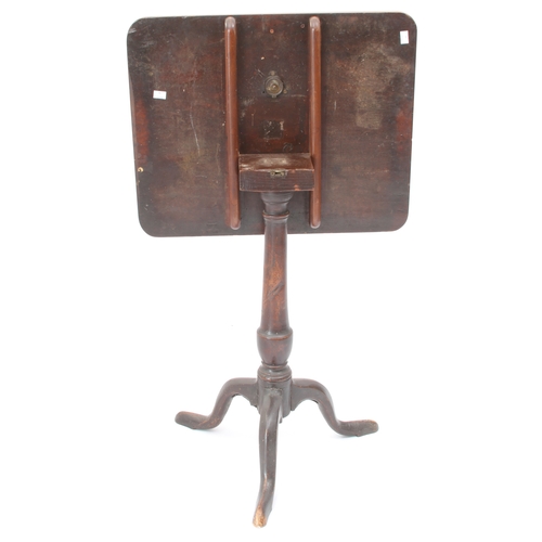 550 - A George III mahogany tilt-top tripod table - the rectangular top on a turned gun-barrel column to t... 