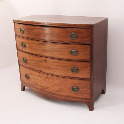 556 - A Regency bowfronted mahogany chest of drawers - with four long drawers with the original oval brass... 