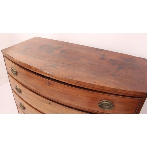 556 - A Regency bowfronted mahogany chest of drawers - with four long drawers with the original oval brass... 