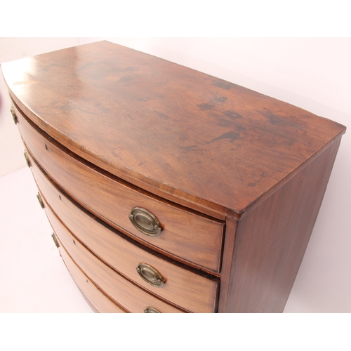 556 - A Regency bowfronted mahogany chest of drawers - with four long drawers with the original oval brass... 