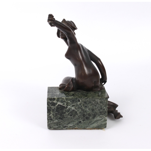 681 - An Art Nouveau bronze of a seated nude maiden - holding a flaming torch in one hand, the other held ... 