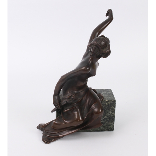 681 - An Art Nouveau bronze of a seated nude maiden - holding a flaming torch in one hand, the other held ... 