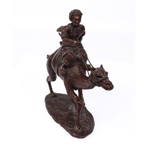 696 - A modern bronze figure of a camel rider - indistinctly signed, with red-brown patination, 23.5cm hig... 