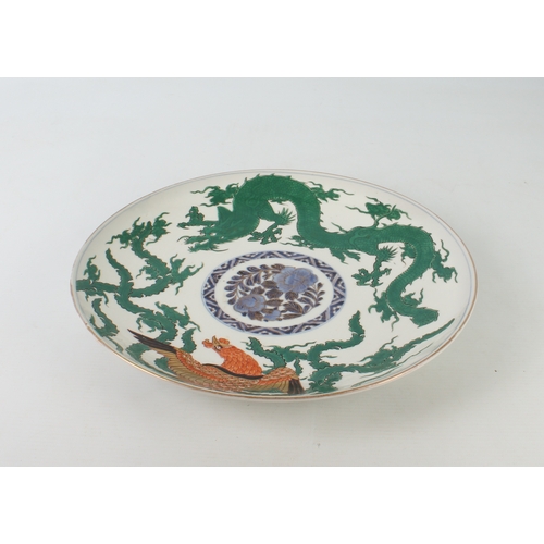 102 - A Japanese Arita porcelain dragon and phoenix saucer dish - made for the Chinese market, painted wit... 