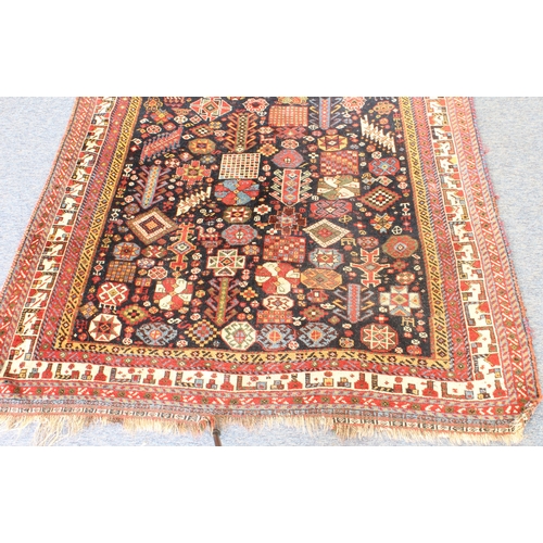 615 - A Qashqai rug - 19th century, the very deep blue ground with dense all over decoration with two huma... 