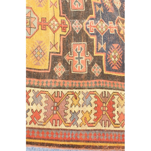 622 - A good Kazak runner - c.1900, with nine central lozenge medallions in blue and deep yellow on a dark... 