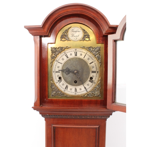 282 - A mahogany cased quarter striking grandmother clock, mid-20th century - the arched brass 'Tempus Fug... 