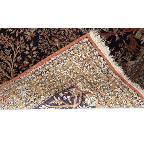 611 - A Turkish Hereke silk tree design rug - late 20th century, the deep blue ground with all over decora... 