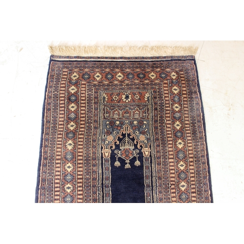 626 - A Pakistan prayer rug - late 20th century, with dark blue central Mihrab with hanging lamp, within a... 