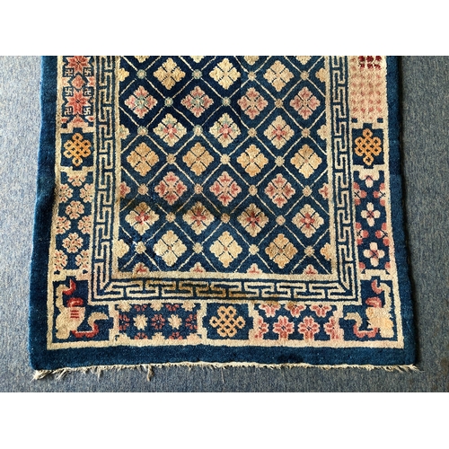 605 - A small Chinese wool rug - mid-20th century, with all over floral decoration on a blue ground, withi... 