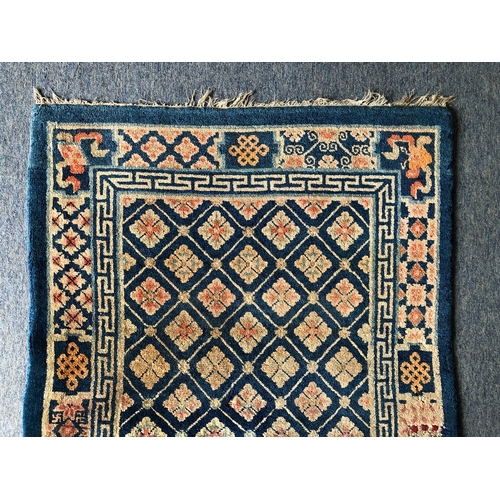 605 - A small Chinese wool rug - mid-20th century, with all over floral decoration on a blue ground, withi... 