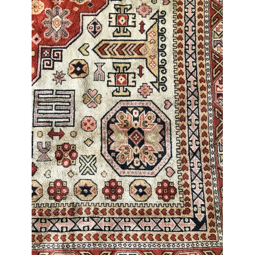 607 - A large Turkish wool rug - mid-2th century, the large, madder lozenge medallion with an inner buff o... 