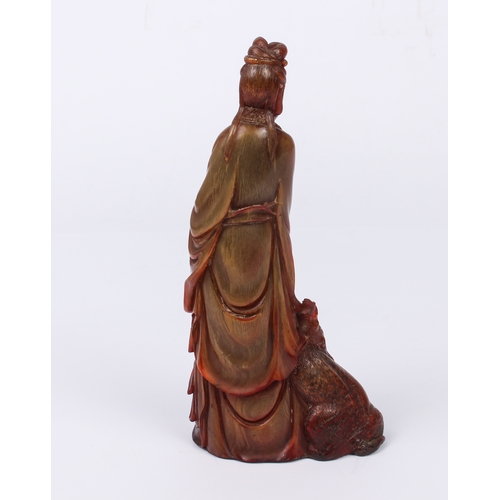 64 - A Chinese red-stained carved horn figure of Guanyin - Qing dynasty, probably 19th century, the figur... 