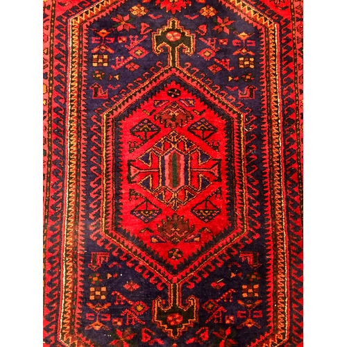 609 - A Hamadan hand-knotted wool rug - late 20th century, the dark-blue and red lozenge hooked pendant me... 