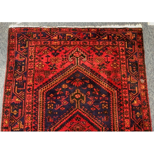 609 - A Hamadan hand-knotted wool rug - late 20th century, the dark-blue and red lozenge hooked pendant me... 