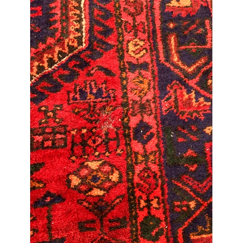 609 - A Hamadan hand-knotted wool rug - late 20th century, the dark-blue and red lozenge hooked pendant me... 