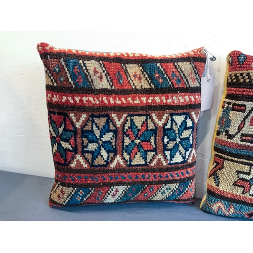 629 - Two Caucasian rug fragment cushions - the larger 36 x 36cm, the other 35 x 34cm.